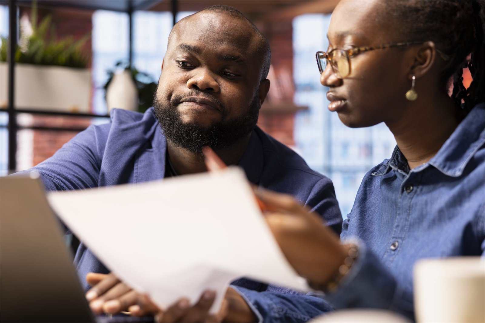 MG Advisory consultant reviewing financial documents with a small business owner in Harare